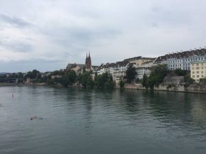 Uitzicht op de stad Bazel. In de Rijn dobberen zwemmers.